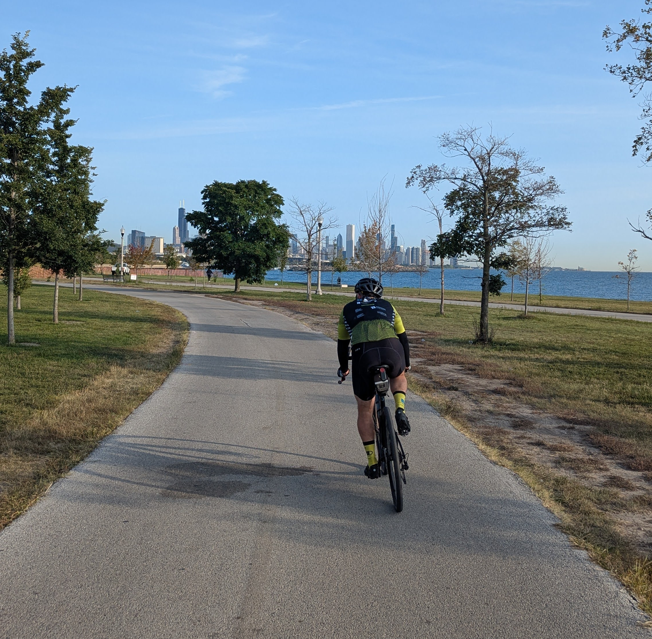 A cyclist riding on a lakeside paved trail during DjangoCon US 2025