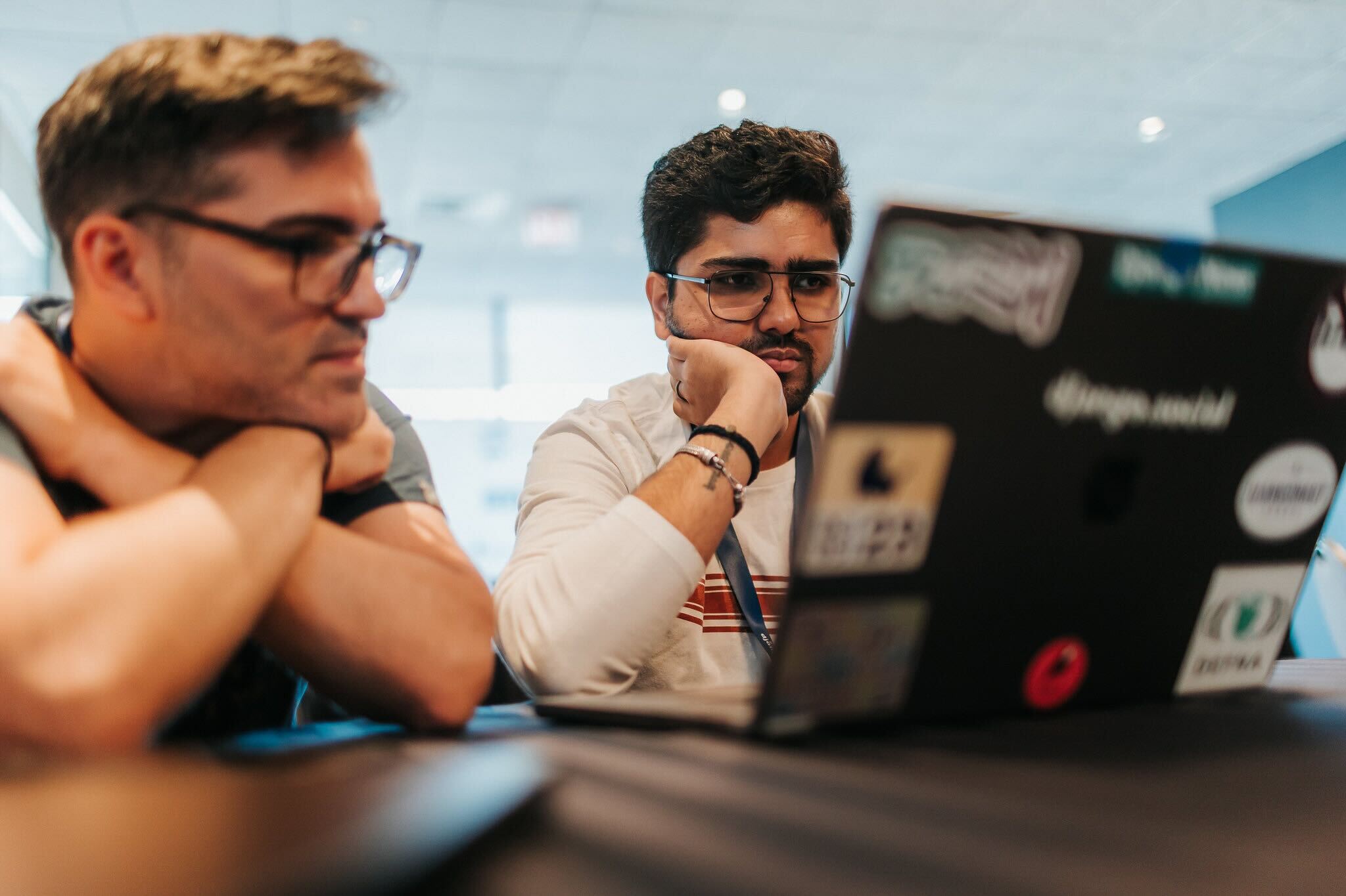 Two sprinters talking through a problem at a laptop during DjangoCon US.